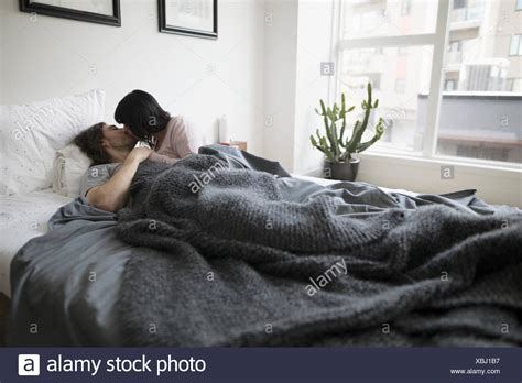 boy and girl kissing in bed